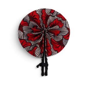 Éventail rond en tissu wax rouge, noir et blanc avec poignées en simili cuir noir fermé par un passant.